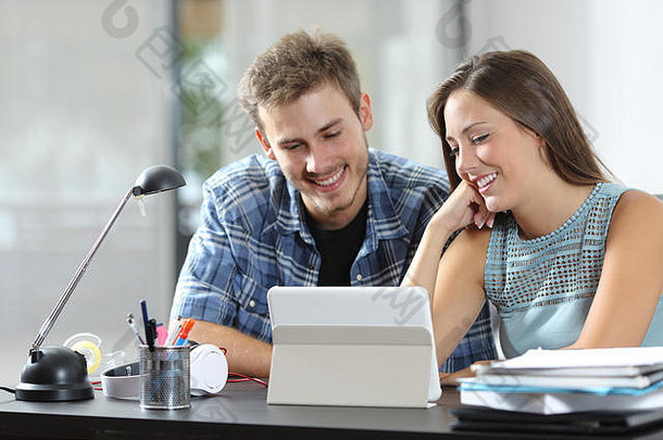 快乐夫妇看平板电脑在线内容坐着桌子上首页