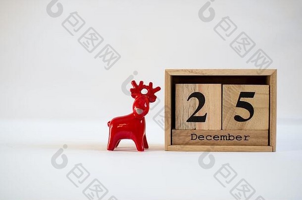 多维数据集木日历显示日期12月陶瓷驯鹿小雕像白色背景出现日历圣诞节背景