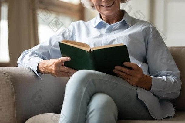 快乐成熟的女人放松沙发上首页阅读书
