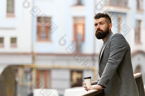 放松充电男人。有胡子的赶时髦的人喝咖啡纸杯sip咖啡城市生活方式商人培养外观享受咖啡打破业务中心城市背景