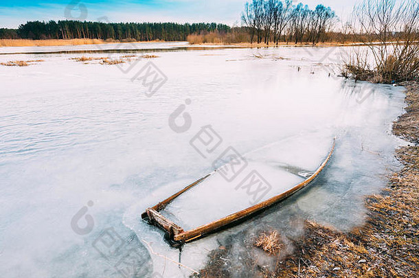 冻冰河湖池塘木船被遗弃的划船钓鱼船冬天河离弃船