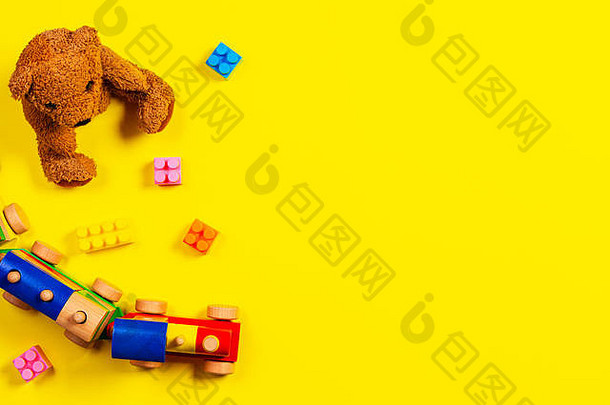 婴儿孩子们玩具背景泰迪熊木火车色彩斑斓的块黄色的背景