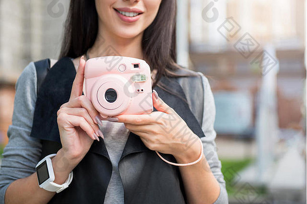 愉快的微笑女人持有照片相机