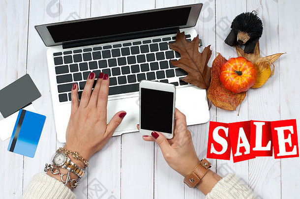 假期出售在线购物概念女人持有智能手机移动PC电脑信贷卡