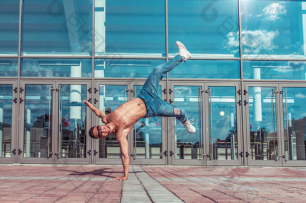 倒立跳年轻的活跃的舞者训练有素的晒黑躯干体育运动男人。城市构成打破舞者臀部跳运动现代跳舞风格青年