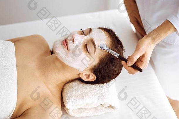 美丽的浅黑肤色的女人女人享受应用化妆品面具关闭眼睛放松治疗医学水疗中心中心概念