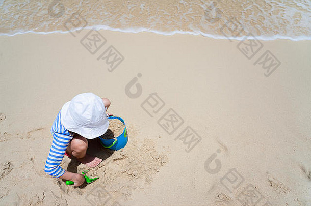 视图女孩穿皮疹警卫太阳保护玩海滩夏天假期