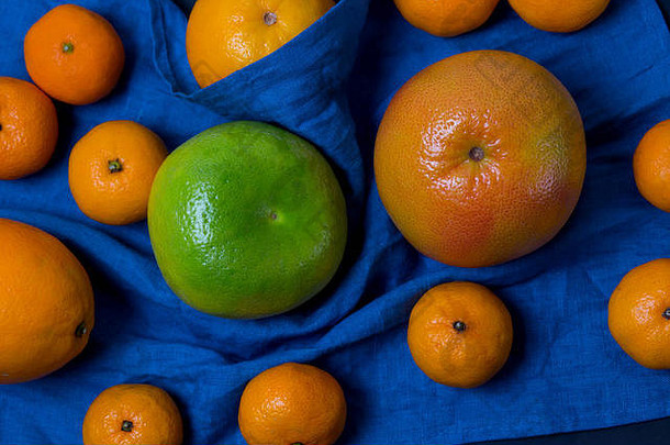 美丽的多汁的开胃的水果柑橘类橙色普通话葡萄柚糖果说谎蓝色的织物背景关闭