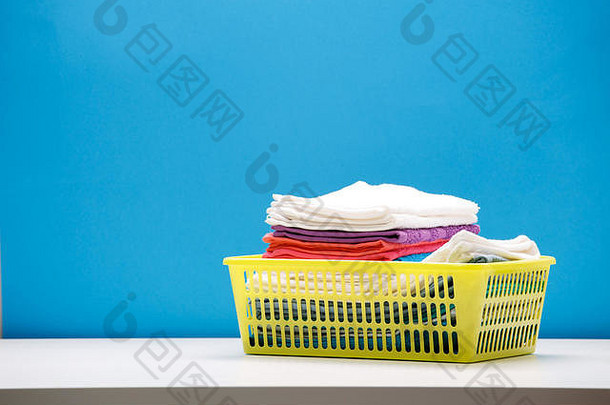 照片多色的浴毛巾黄色的篮子空蓝色的背景