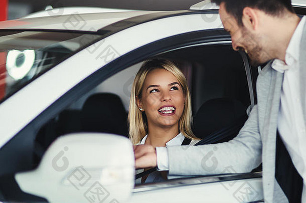 女人会说话的英俊的车经销商工人选择车