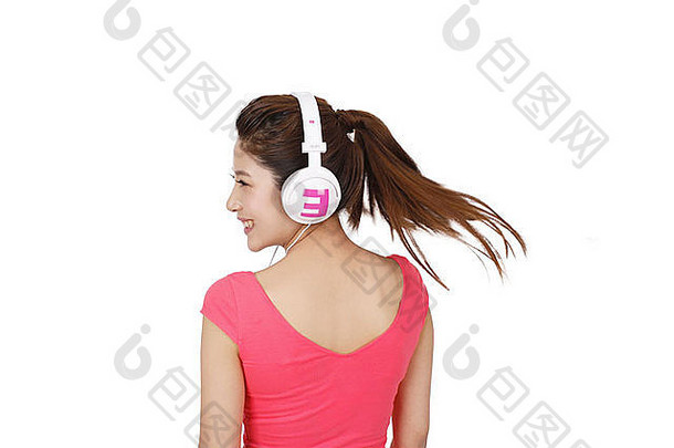年轻的女人粉红色的衣服耳机