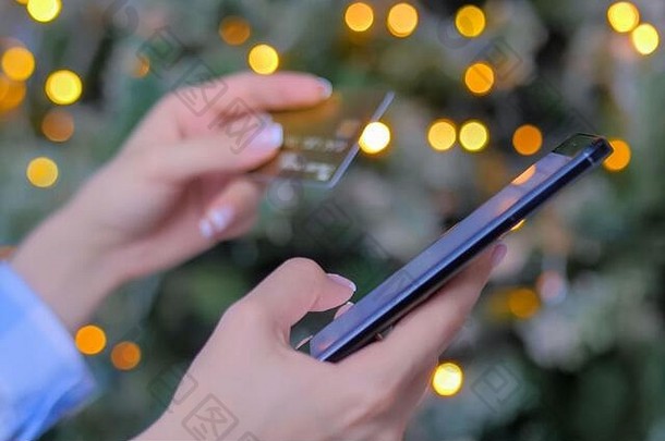 女人智能手机信贷卡在线购物圣诞节背景