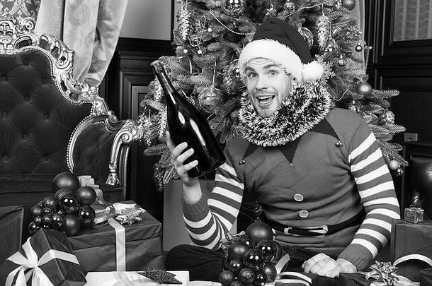 男人。圣诞老人他微笑香槟瓶礼物给拳击一天快乐一年圣诞节假期庆祝活动聚会，派对概念男子气概精灵服装现在盒子圣诞节树