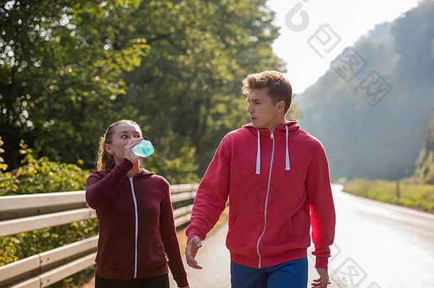 年轻的夫妇享受健康的生活方式慢跑国家路锻炼健身概念