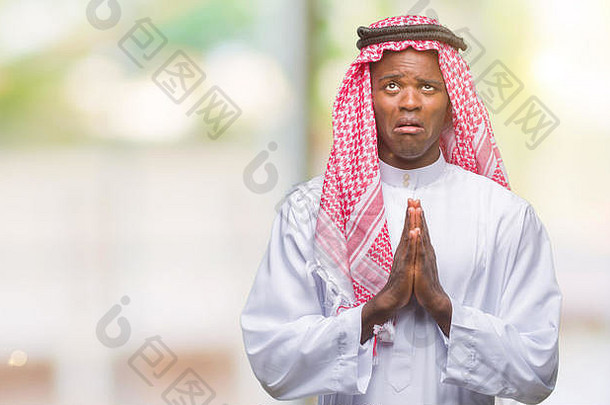 年轻的阿拉伯语非洲男人。穿传统的阿拉伯人的头巾孤立的背景乞讨祈祷手希望表达式脸