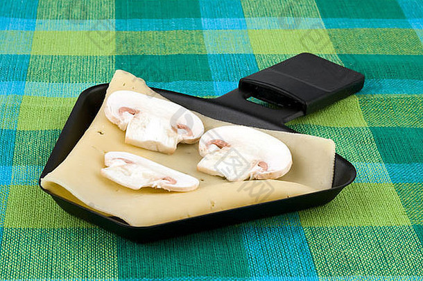 烤奶酪锅伊丹奶酪切片蘑菇色彩斑斓的桌布