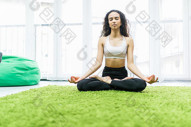 有吸引力的年轻的女人锻炼坐着瑜伽莲花位置休息首页