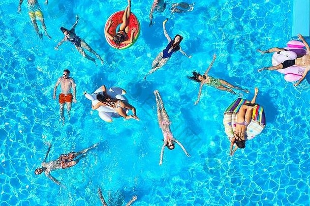 空中朋友聚会，派对游泳池充气火烈鸟天鹅床垫快乐年轻的人放松奢侈品度假胜地阳光明媚的一天视图