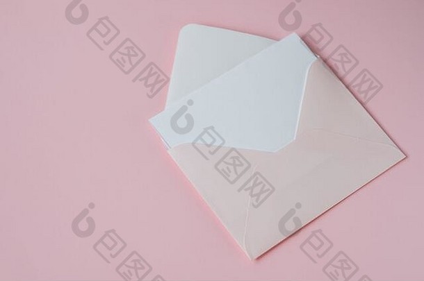粉红色的信封白色空白纸孤立的柔和的粉红色的背景