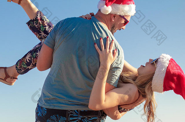 男人。携带女朋友圣诞节帽子太阳镜海滩海