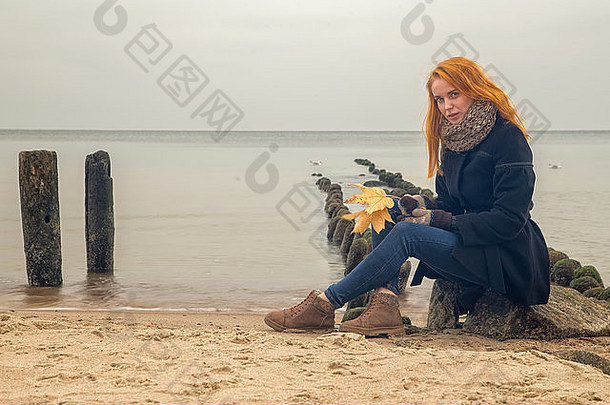 伤心沉思的女人秋天海海滩坐着相机