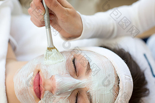 化妆师应用面部护肤品面具客户