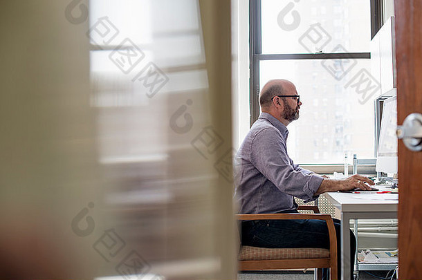 办公室生活男人。坐着桌子上电脑专心地屏幕