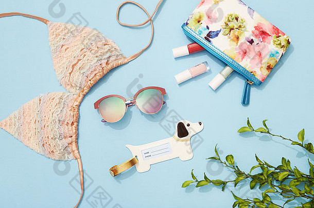 年轻的女人海滩假期时尚美产品配件平躺蓝色的背景
