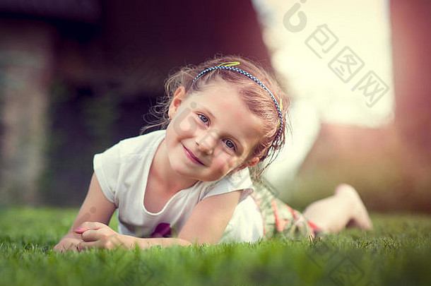 微笑女孩白色衣服铺设新鲜的草坪上