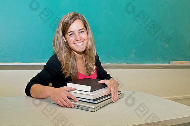 拉美裔女大学学生坐着前面黑板上教科书