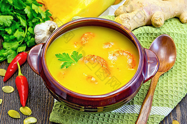 soup-puree南瓜虾粘土碗勺子毛巾南瓜欧芹热红色的胡椒豆荚南瓜种子