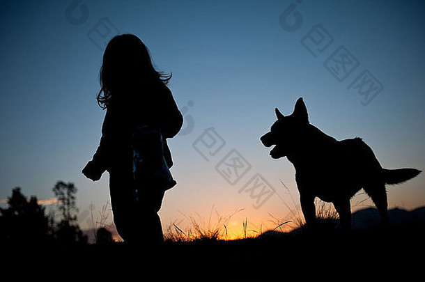 美丽的日落轮廓年轻的蹒跚学步的女孩波浪头发走场狗密切