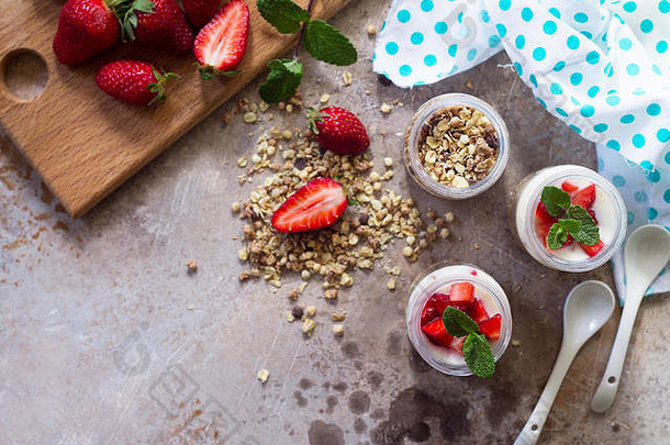 自制的健康的早餐自制的烤格兰诺拉麦片新鲜的草莓酸奶石头混凝土表格
