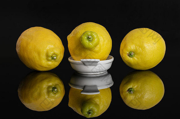 集团新鲜的黄色的柠檬白色椭圆形陶瓷碗孤立的黑色的玻璃
