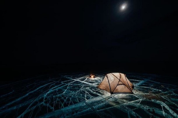 火冰晚上营地冰帐篷站篝火湖贝加尔湖附近的车避难所帐篷冰照亮