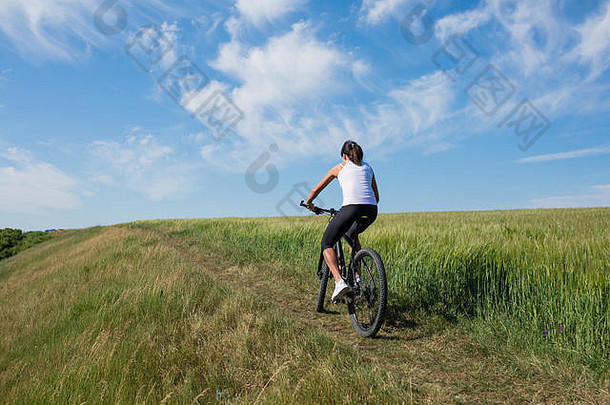 山骑自行车快乐运动型女孩放松梅多斯阳光明媚的农村