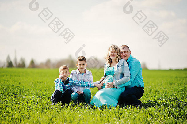 快乐怀孕了家庭儿子穿着绿松石衣服支出时间绿色草场