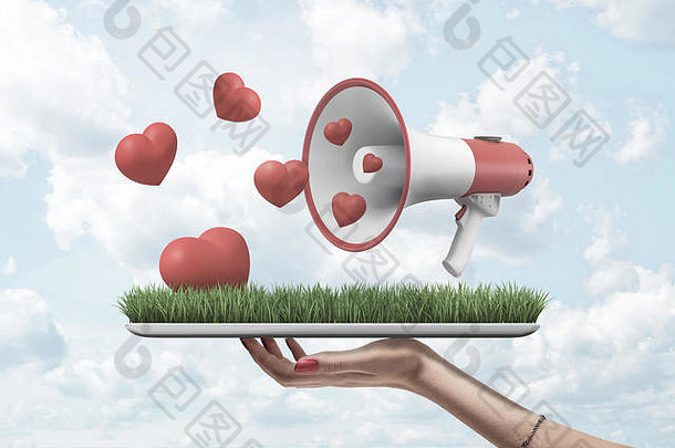 女人的手持有数字平板电脑草屏幕扩音器空气可爱的红色的心飞行