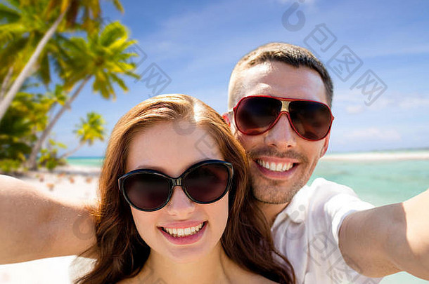 夫妇太阳镜使自拍海滩
