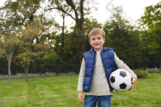 快乐男孩站在户外足球球