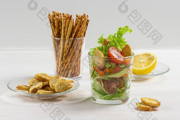 新鲜的蔬菜沙拉透明的玻璃白色樱桃西红柿黄瓜生菜油炸面包丁柠檬汁沙拉酱咸薯片玻璃片