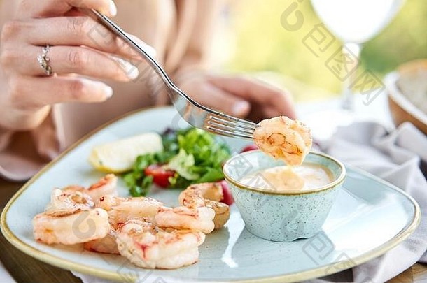 烤阿根廷虾mango-jalapeno酱汁午餐餐厅女人吃美味的健康的食物美味的新鲜的海鲜虾