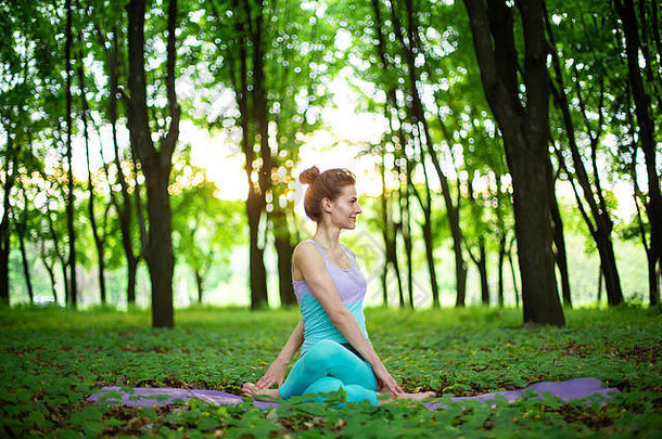 年轻的体育女孩实践瑜伽辞职绿色夏天森林瑜伽阿三的姿势冥想团结自然
