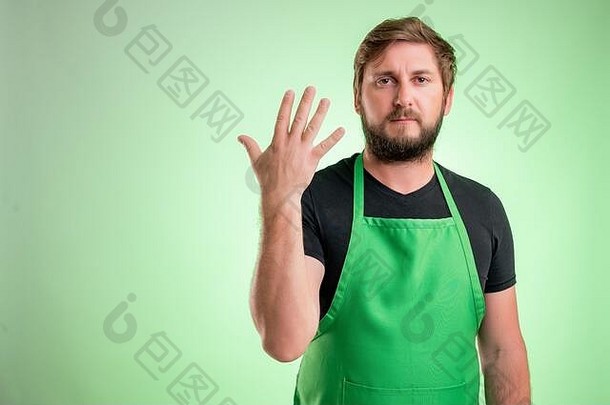 超市员工绿色围裙黑色的t恤计数手指孤立的绿色背景