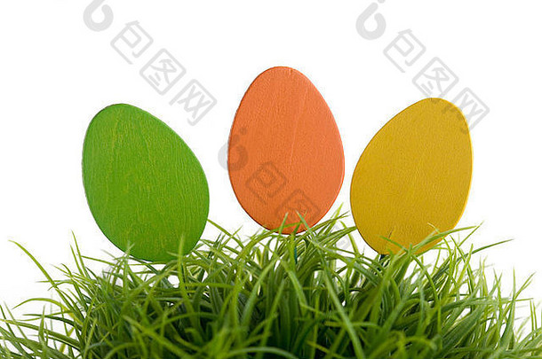 色彩斑斓的复活节鸡蛋绿色草孤立的白色
