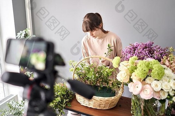 女人写视频博客在线花学校概念花店女人创建花安排柳条篮子花交付