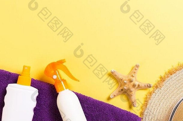 海滩平躺配件复制空间紫罗兰色的毛巾贝壳关节遮阳帽瓶防晒霜黄色的背景夏天假期概念