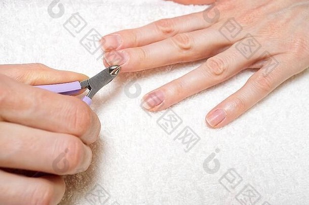 女人的手删除指甲角质层光白色表格护理干杂草丛生的角质层特写镜头