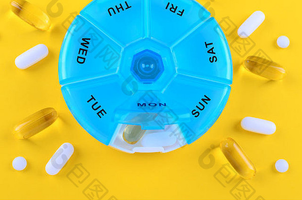 药物ω胶囊周蓝色的药片盒子黄色的背景