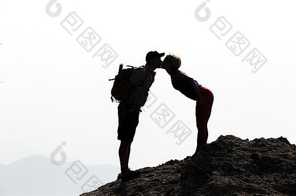 快乐夫妇接吻山峰会轮廓徒步旅行者成功山前接吻成功健康的生活方式吻